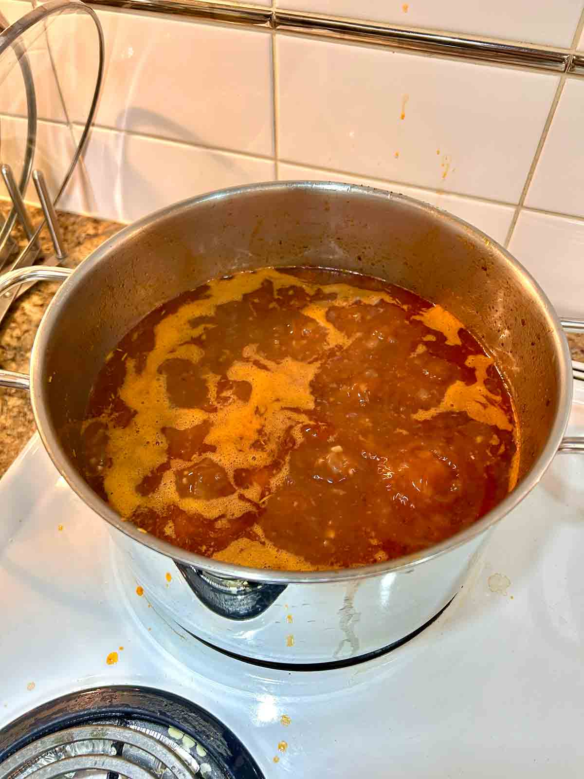 tomato paste, beef broth, and seasonings added to pot.