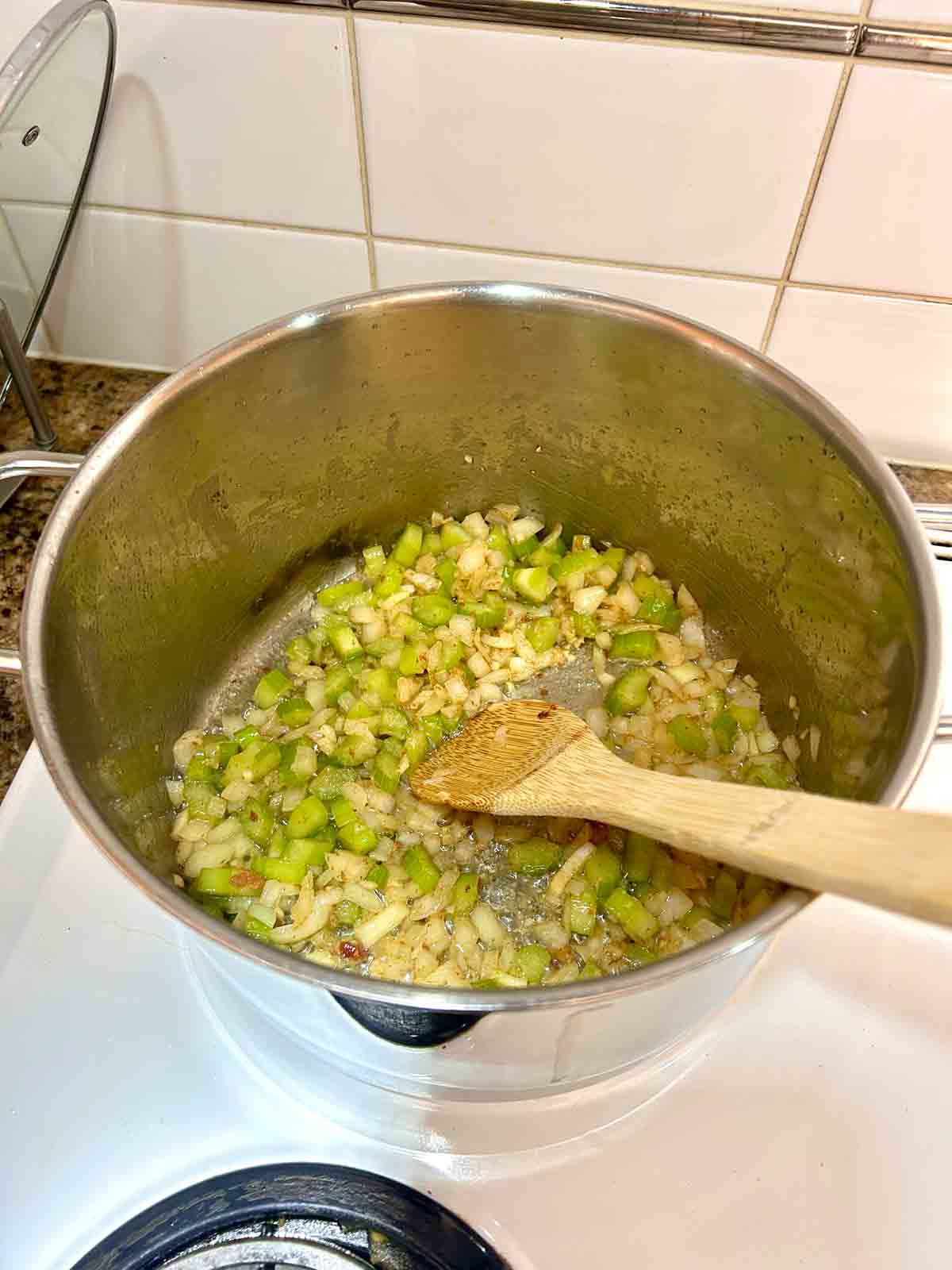 onions, garlic, and celery being cooked in bacon fat.
