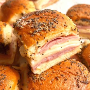 one slice of ham and cheese slider on top of others.