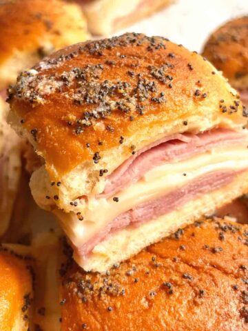 one slice of ham and cheese slider on top of others.