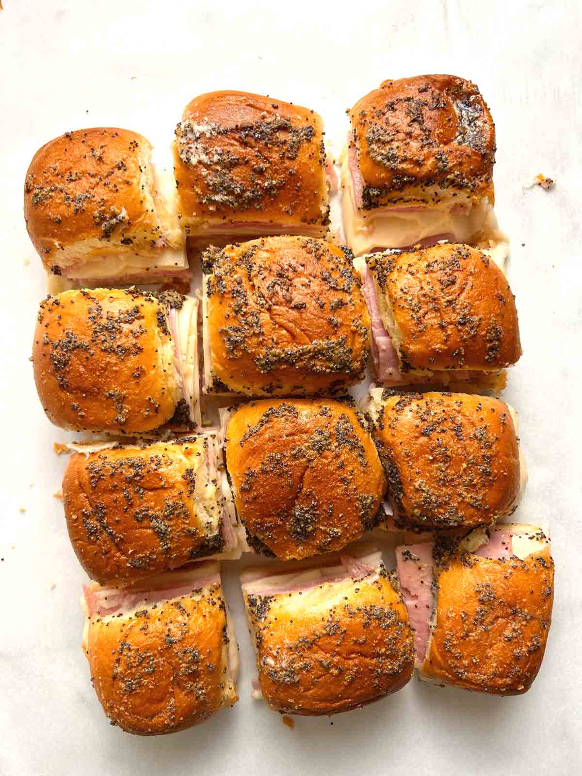 sliders cut into pieces and arranged on parchment paper.