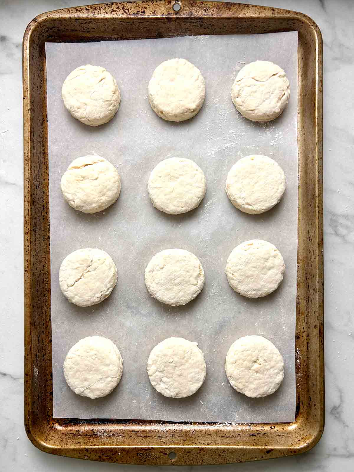 biscuit dough circles arranged on baking sheet.
