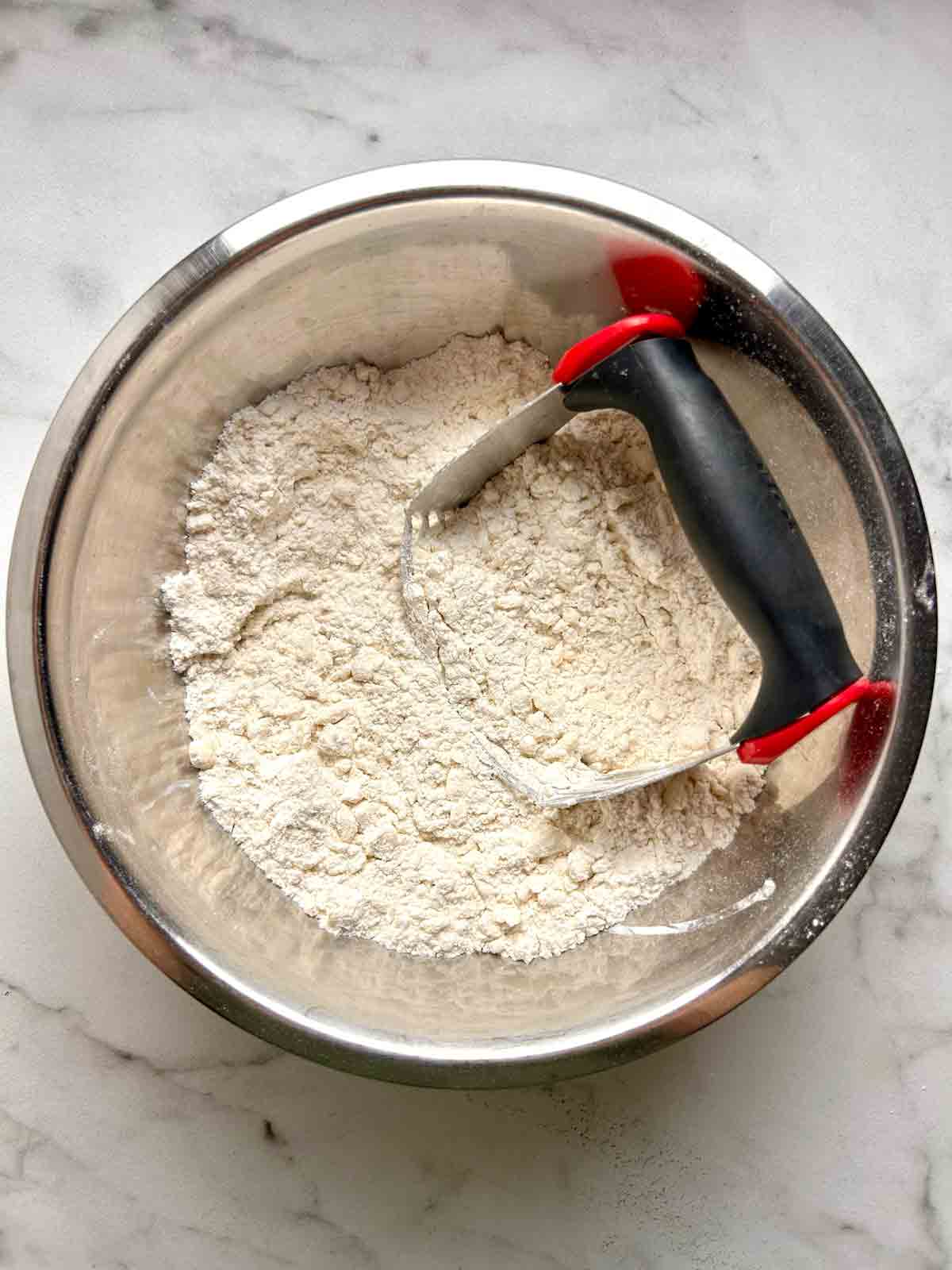 butter being cut into flour mixture.