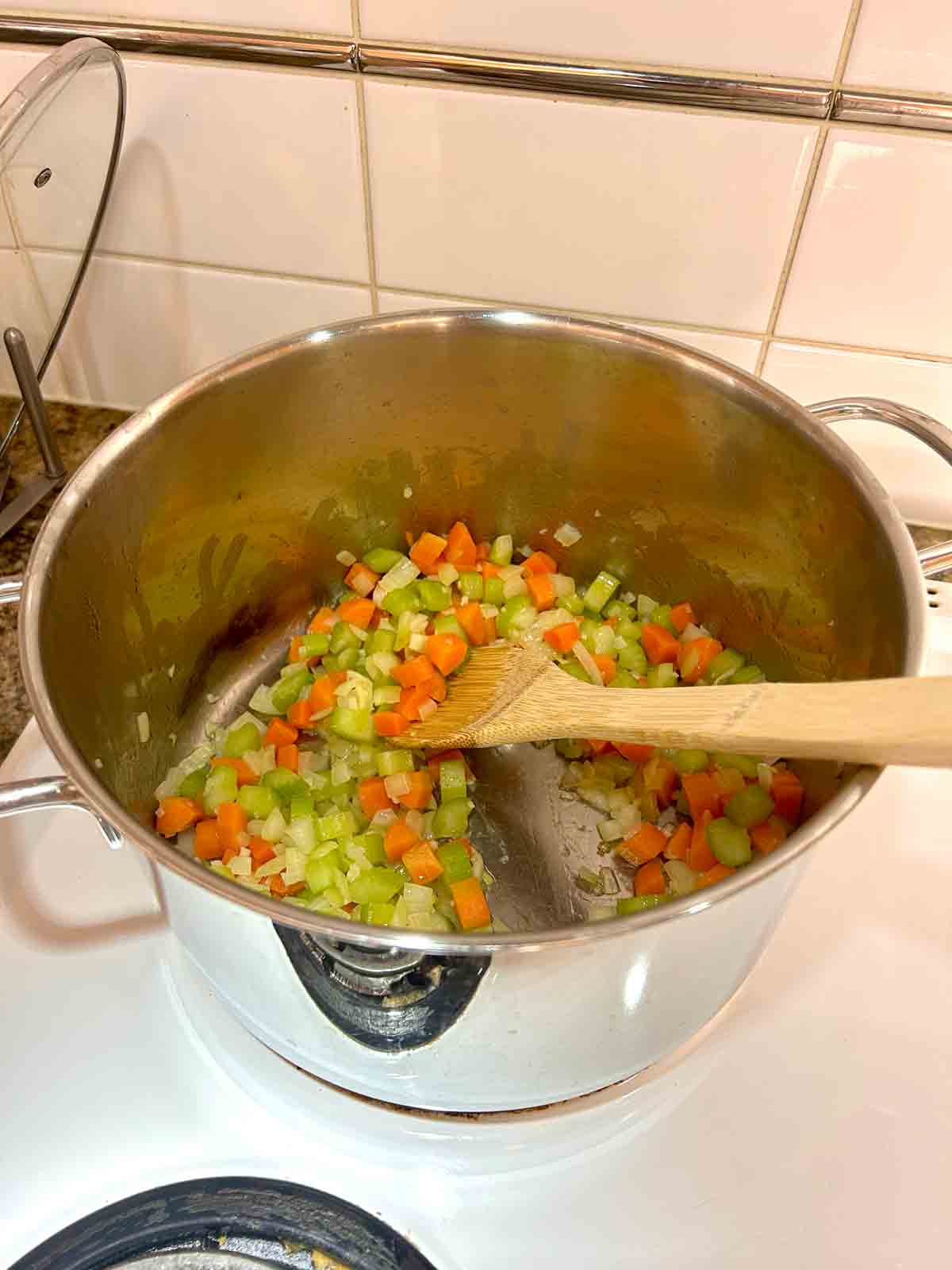 vegetables being sautéed in pot.