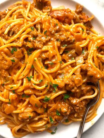 plate of cheesy taco spaghetti garnished with parsley.