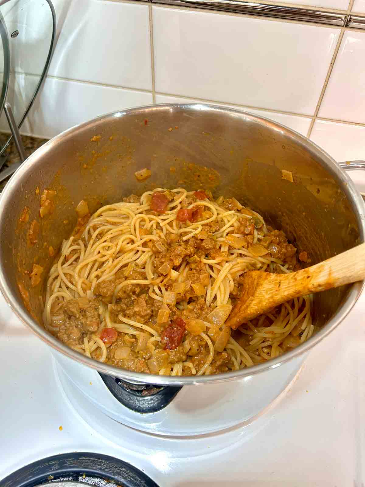 spaghetti added to pot of sauce and tossed.