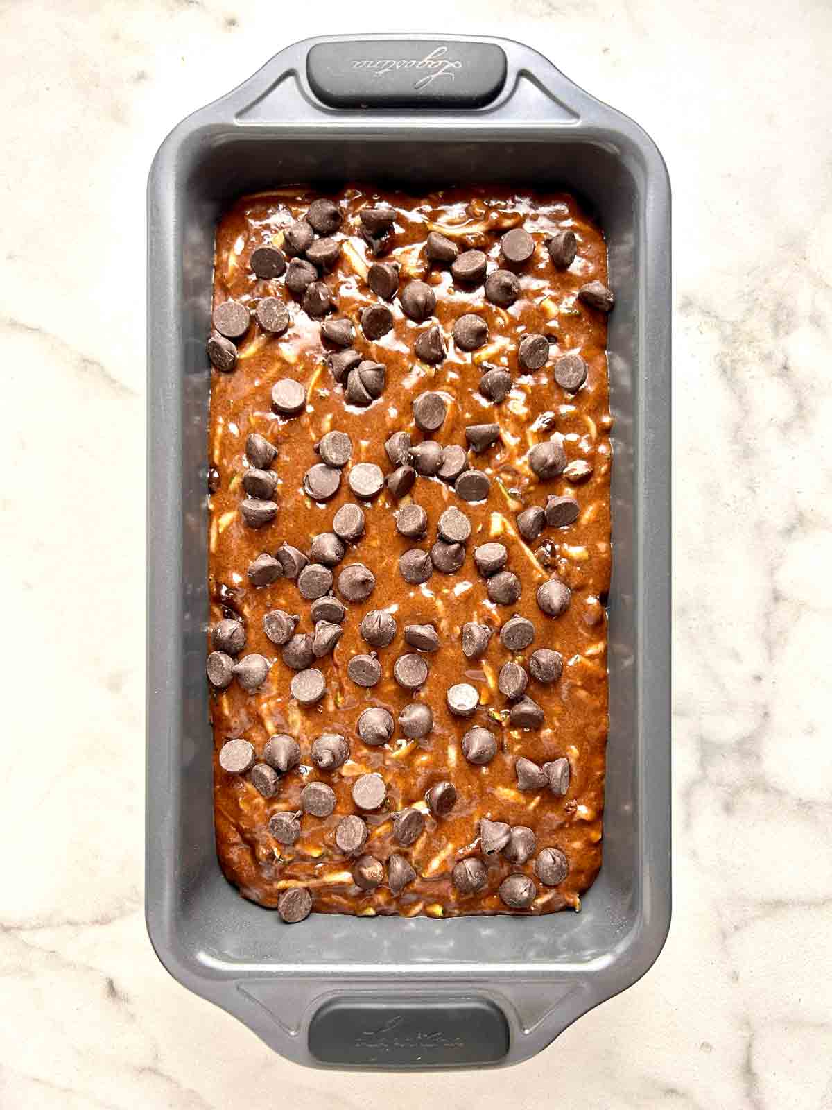 chocolate chips sprinkled on top of batter in loaf pan.