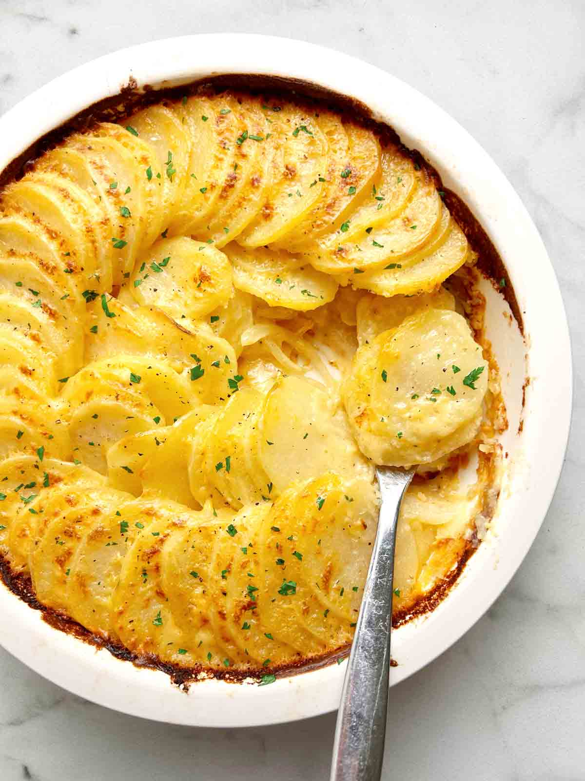 close up of potatoes au gratin in baking dish.
