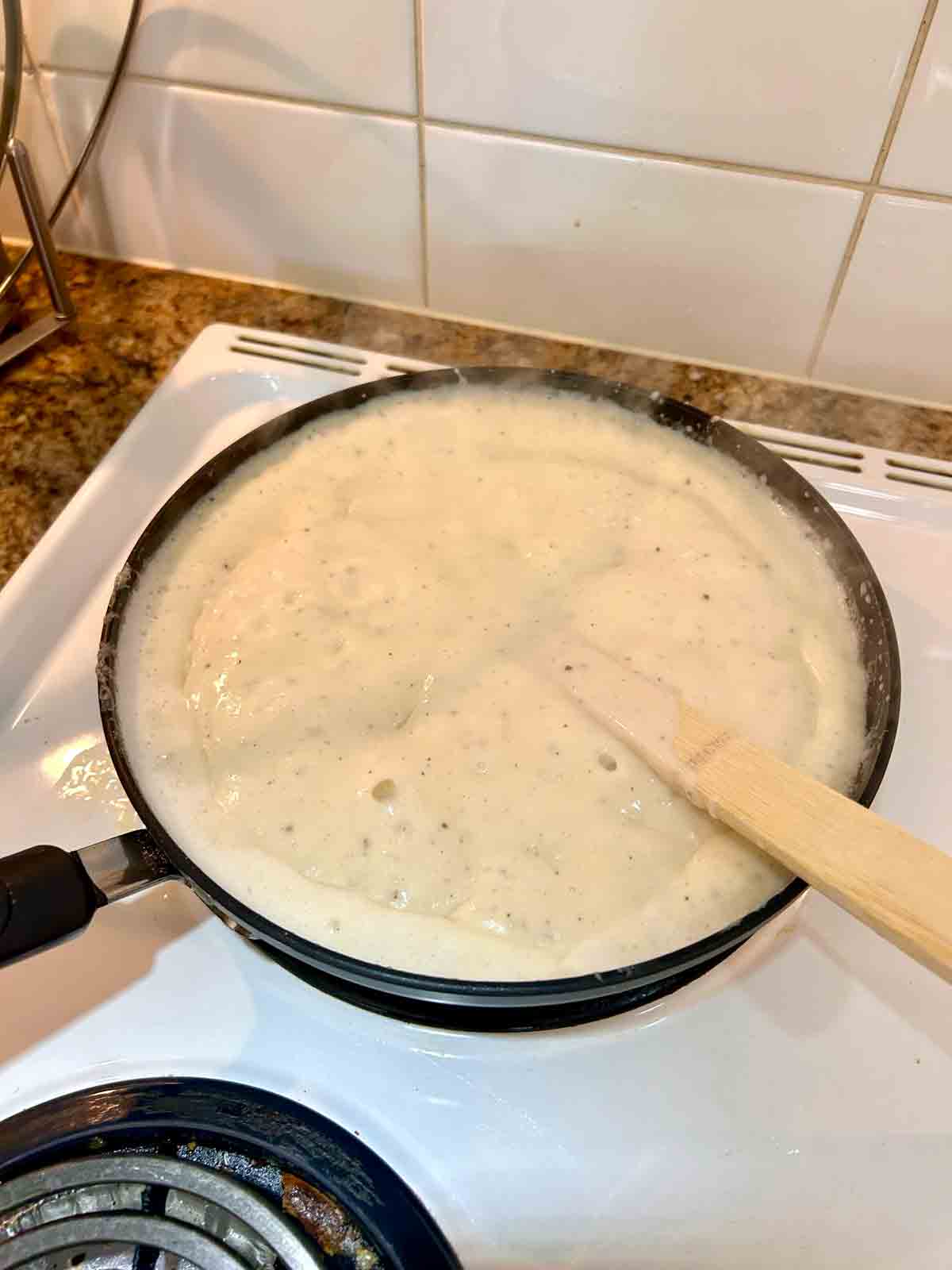 cheese sauce boiling in pan.