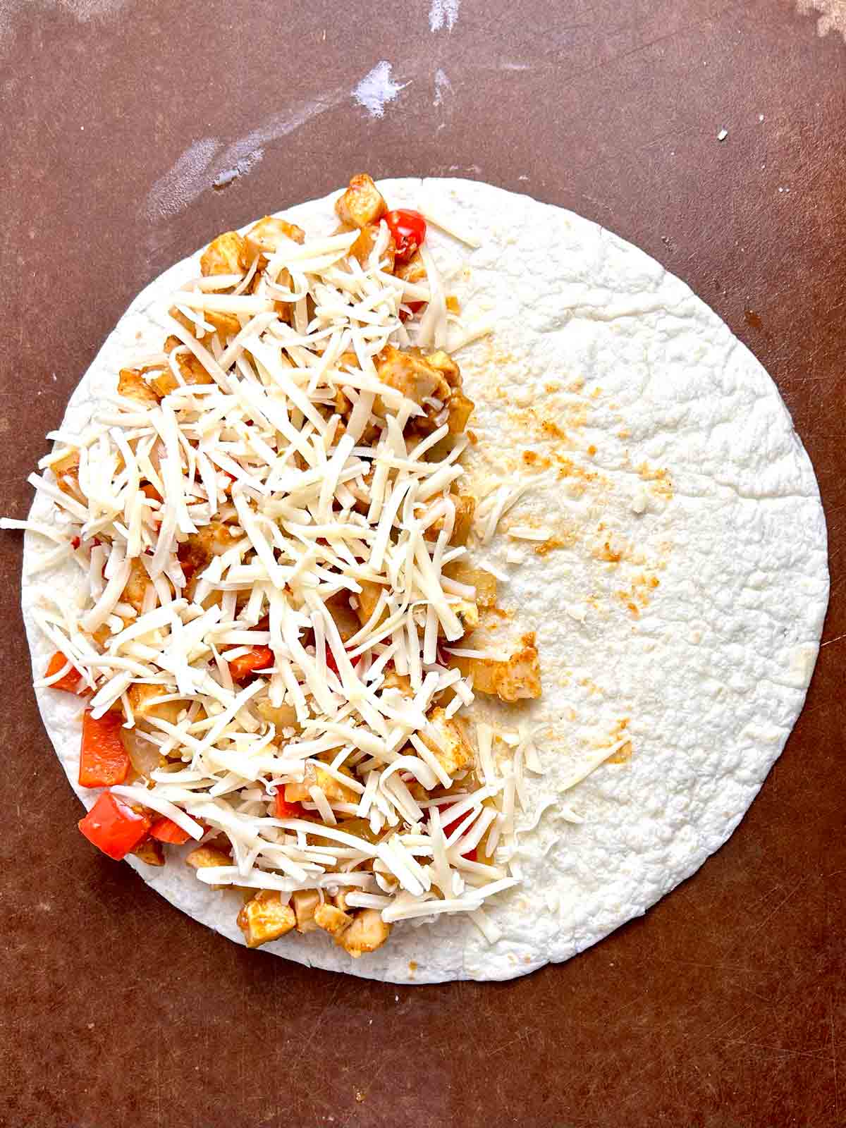 filling and cheese added on top of half of tortilla.