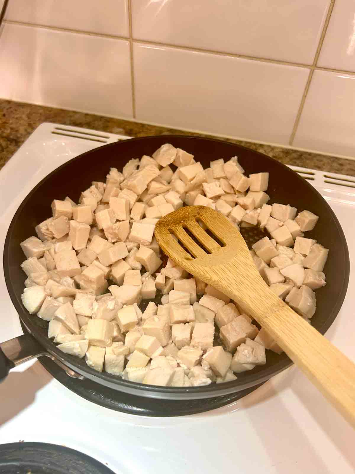 chicken being cooked in pan.