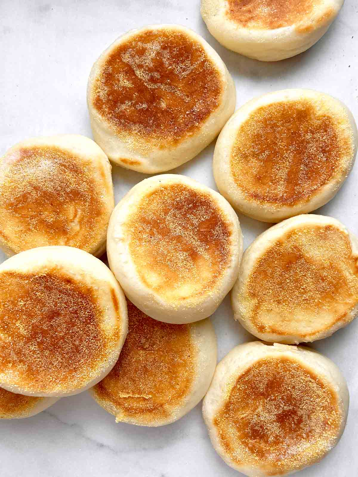 English muffins scattered on parchment paper.