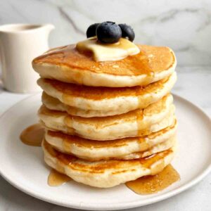 stack of sourdough pancakes with syrup pouring over them.