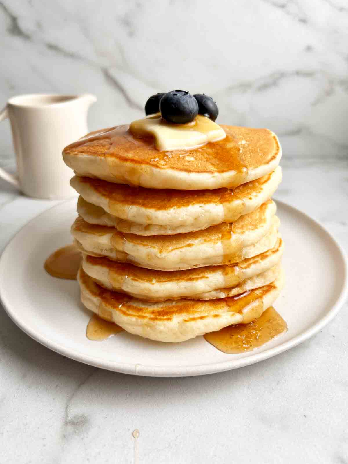 stack of sourdough pancakes with syrup pouring over them.