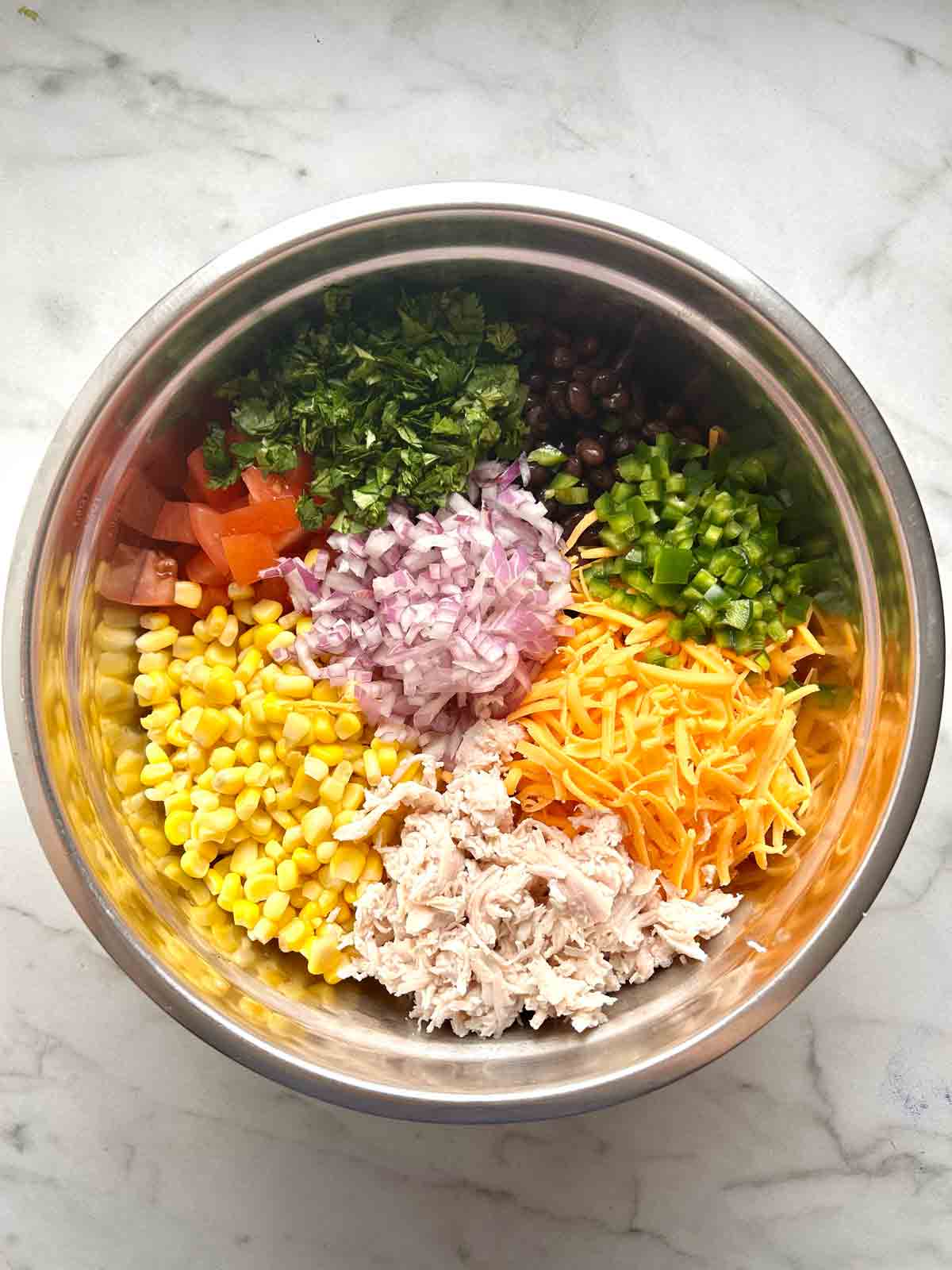 vegetables and chicken arranged in big bowl.