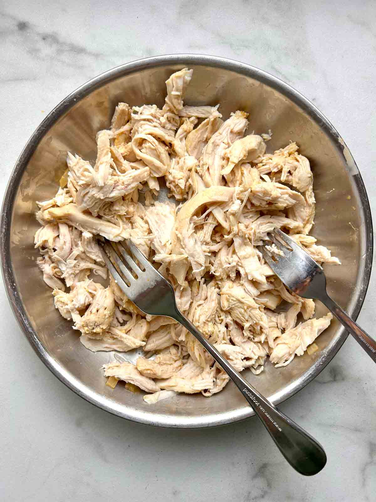 chicken shredded with forks in bowl.