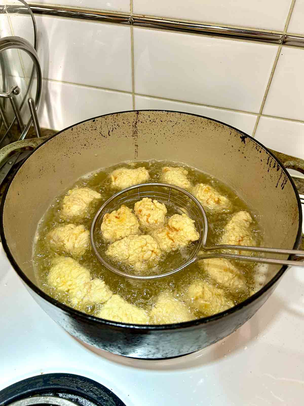 chicken pieces being fried in oil.