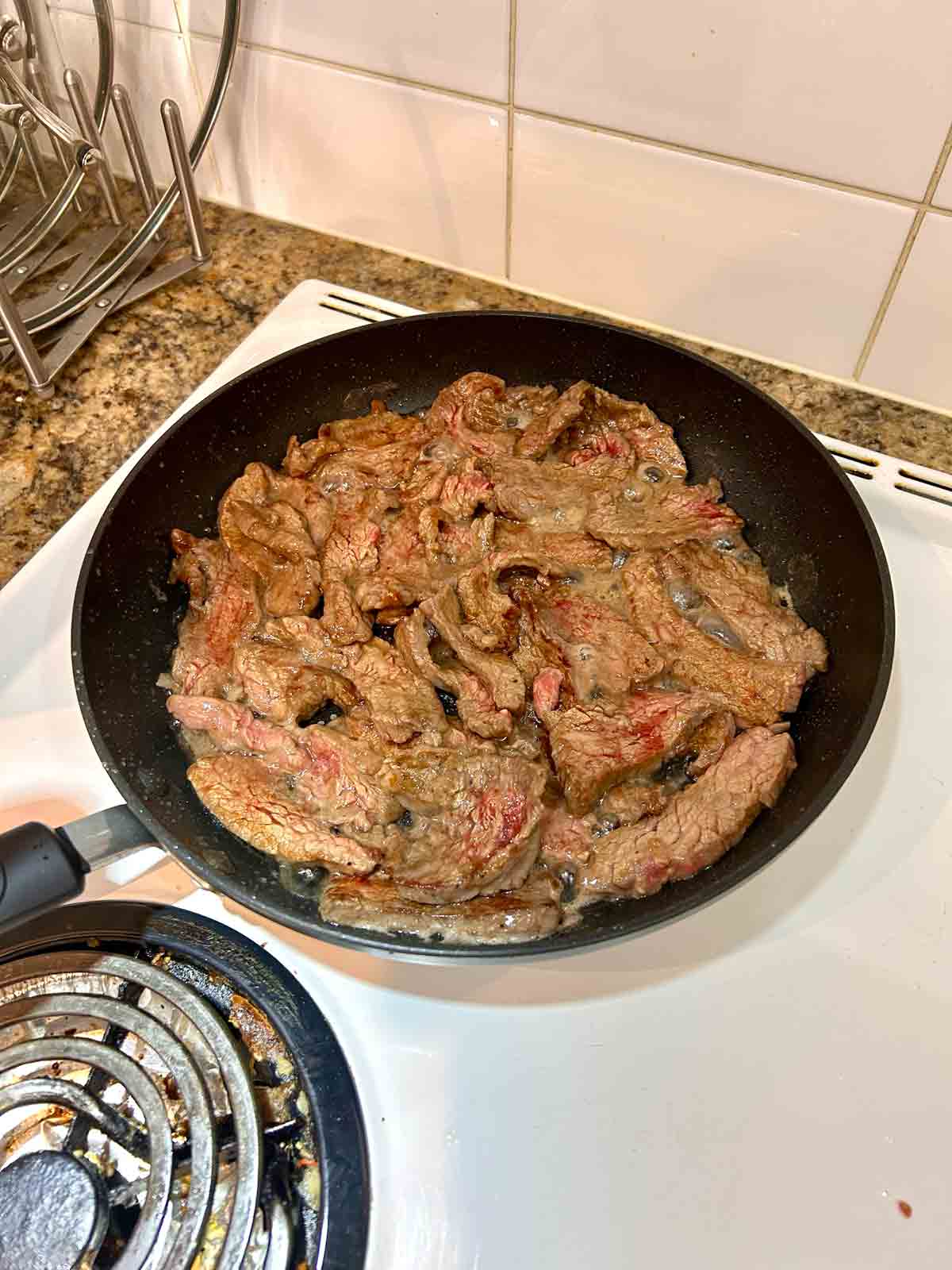 beef cooking until brown on outside in skillet.