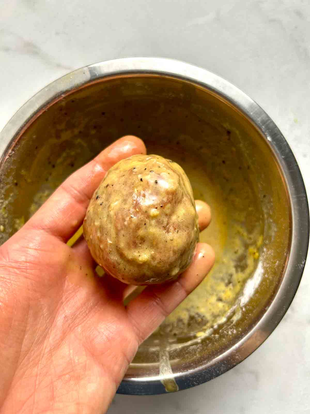egg being coated in egg wash.