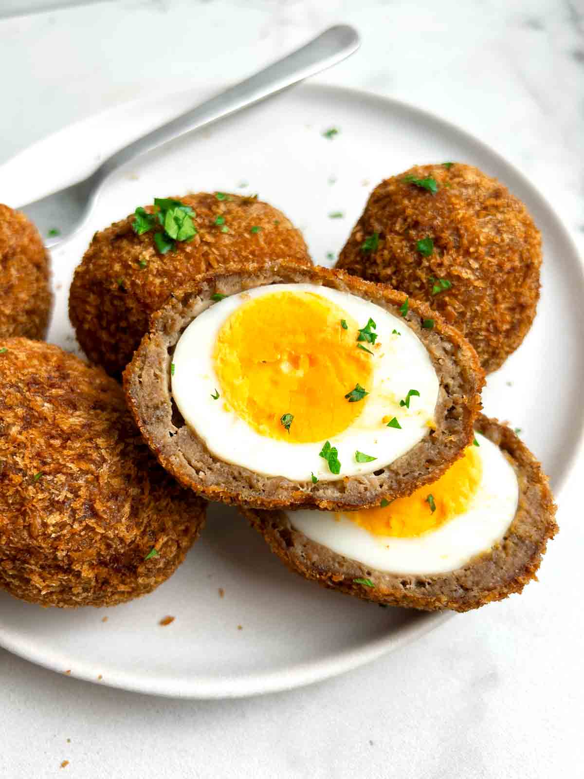 close up of scotch egg cut in half.