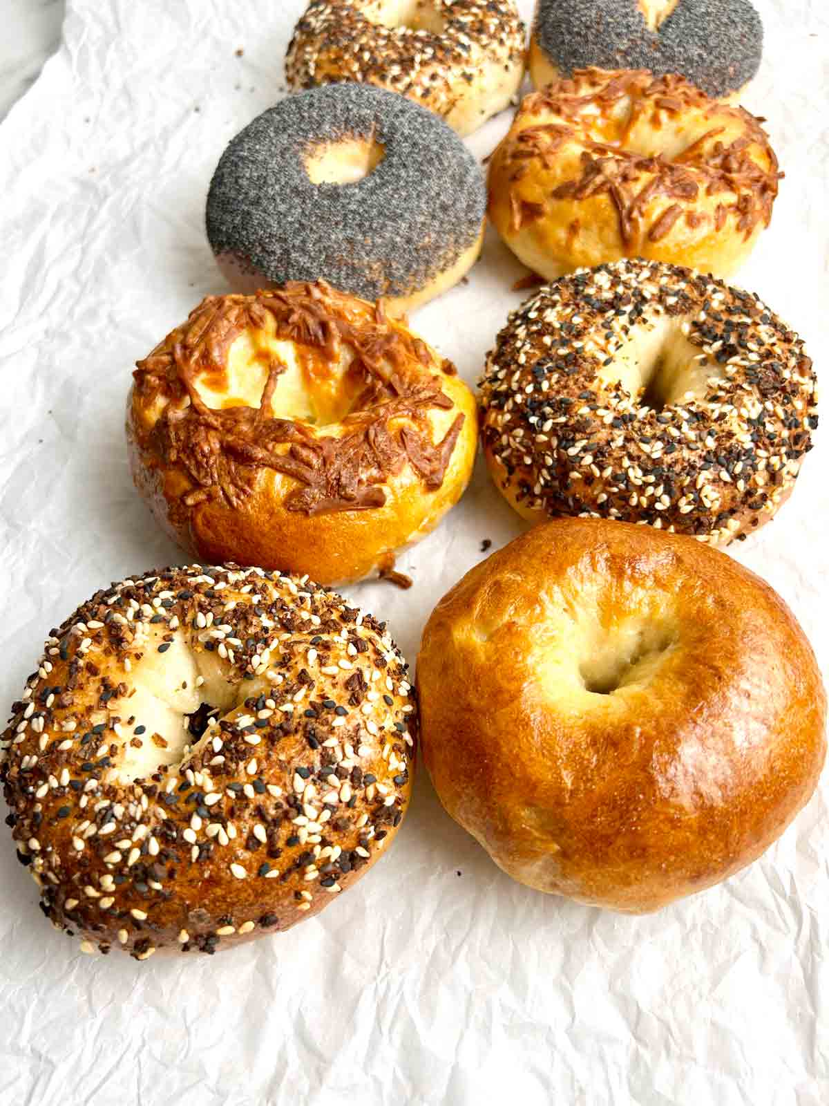 assorted sourdough bagels on parchment paper.