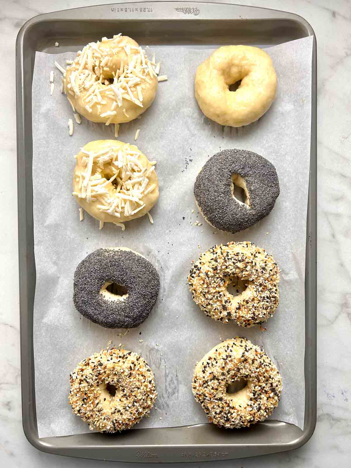 boiled bagels with seasonings on top.