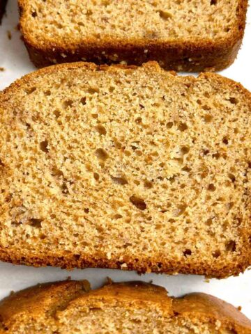close up of slices of banana bread on parchment paper.