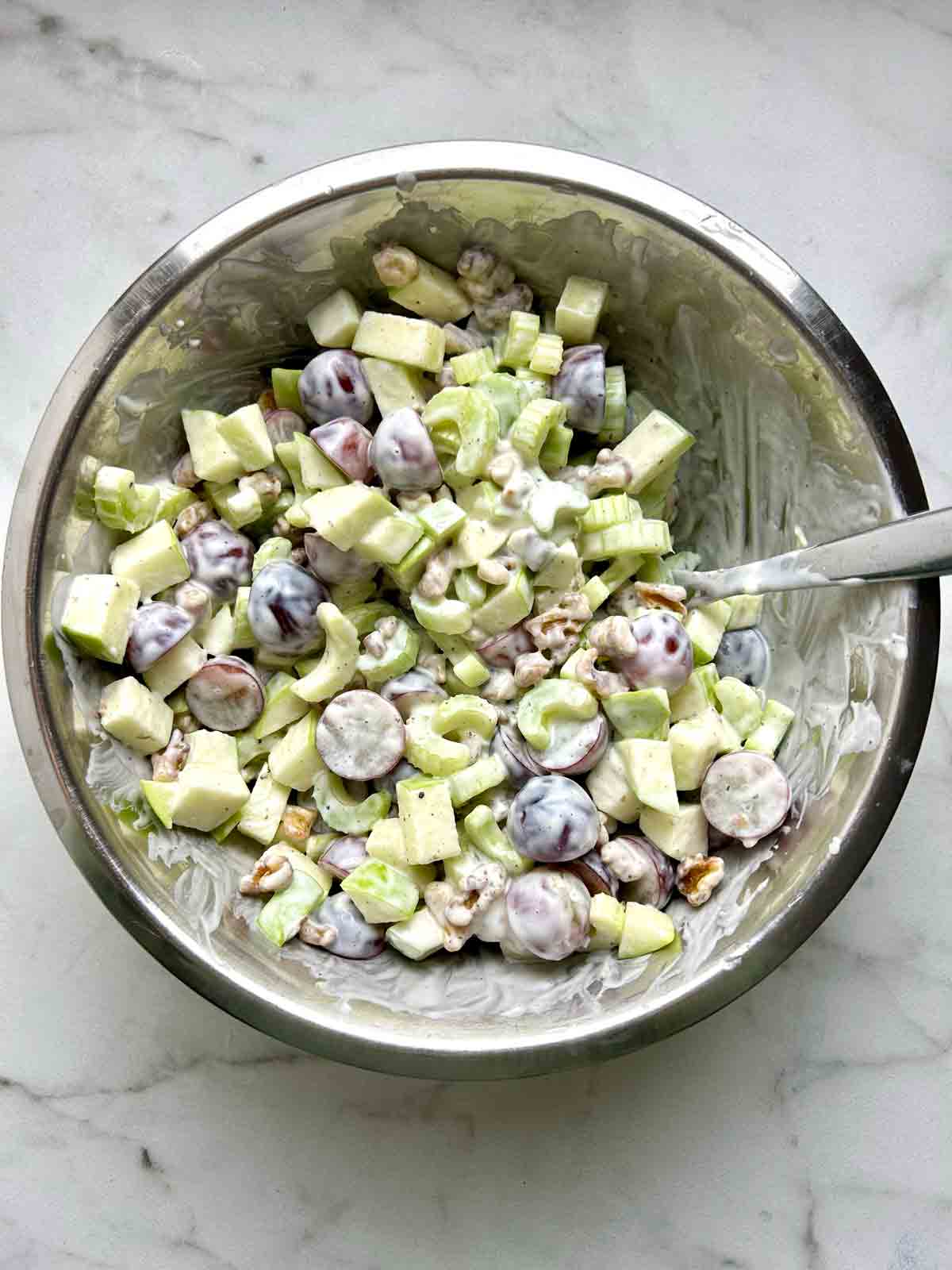 salad tossed with dressing in bowl.