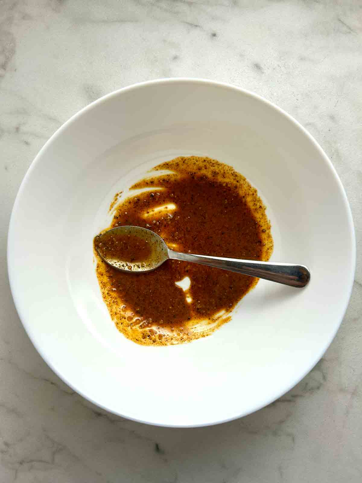 spice rub mixed with cornstarch and olive oil in white bowl.
