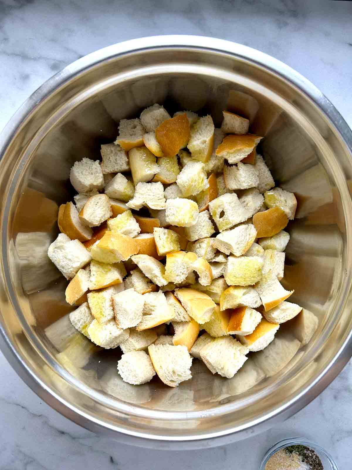 bread cubes tossed with olive oil in bowl.
