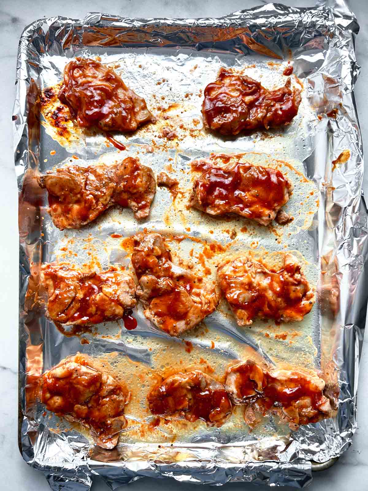 chicken thighs flipped over and brushed with more barbecue sauce.