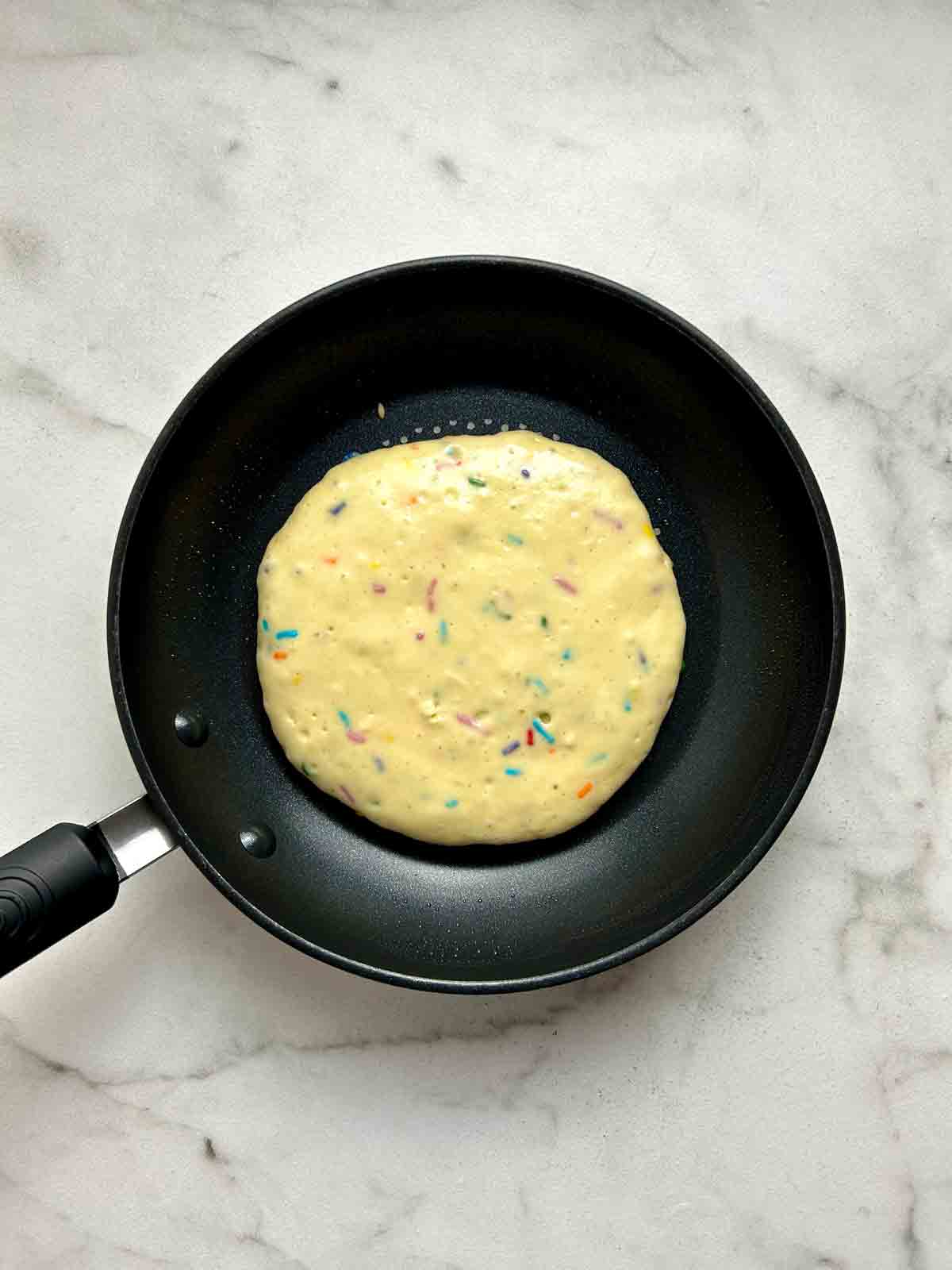 first side of pancake being cooked.