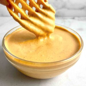 waffle fry being dipped in chipotle sauce.