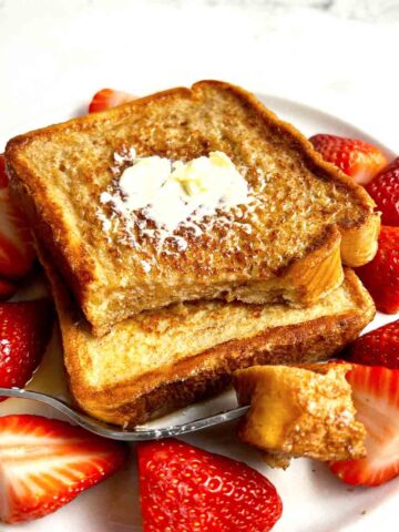 plate of French toast with strawberries on side.