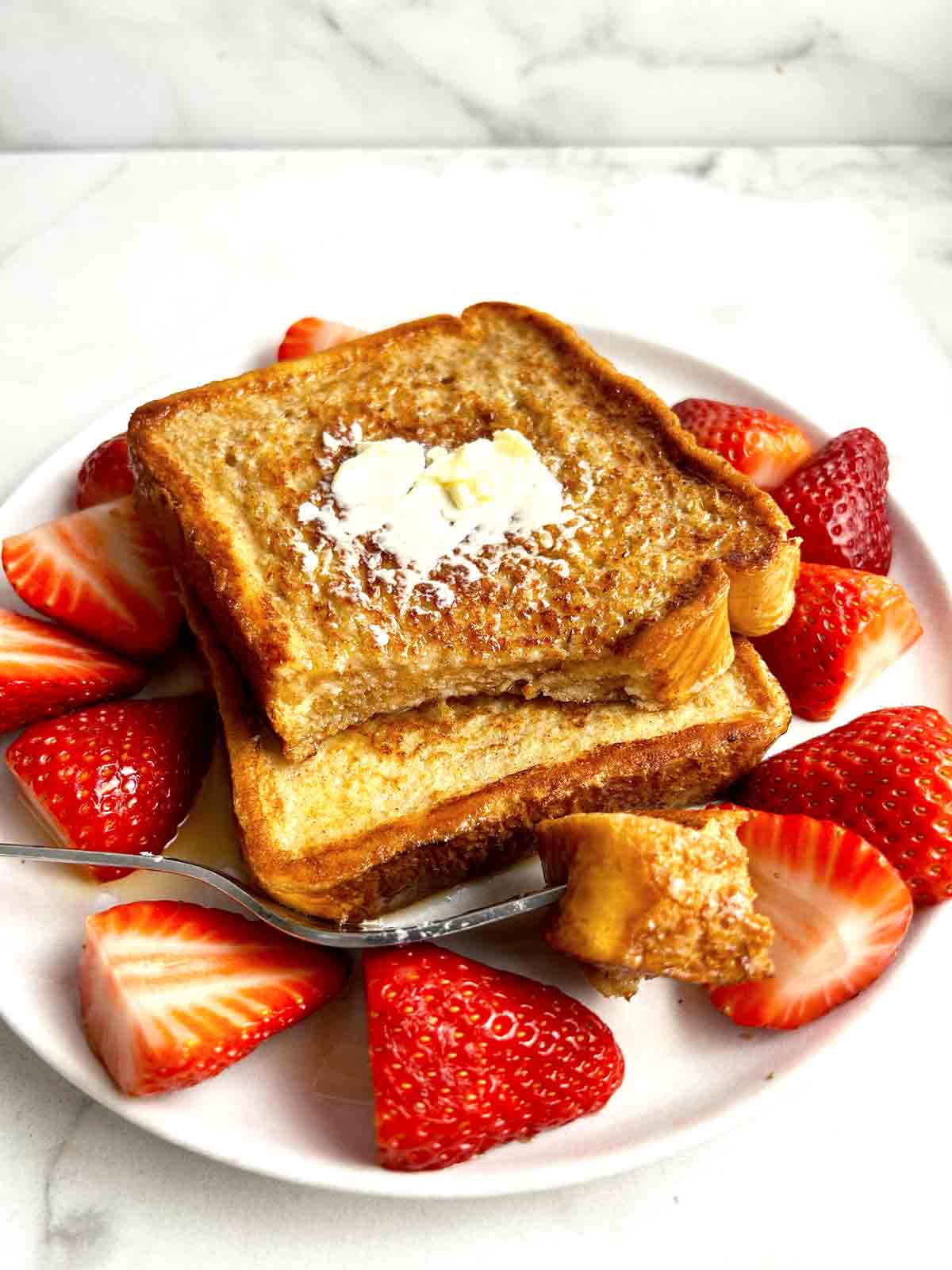 plate of French toast with strawberries on side.