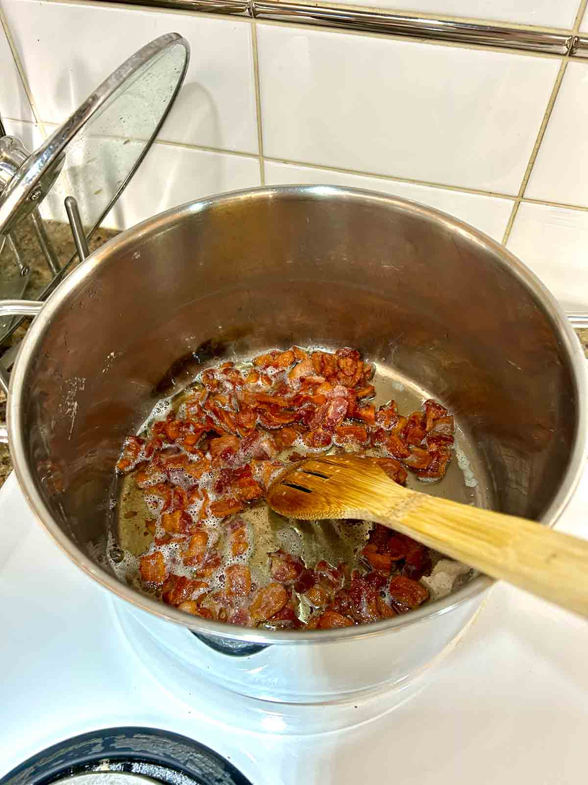 crispy bacon cooking in pot.