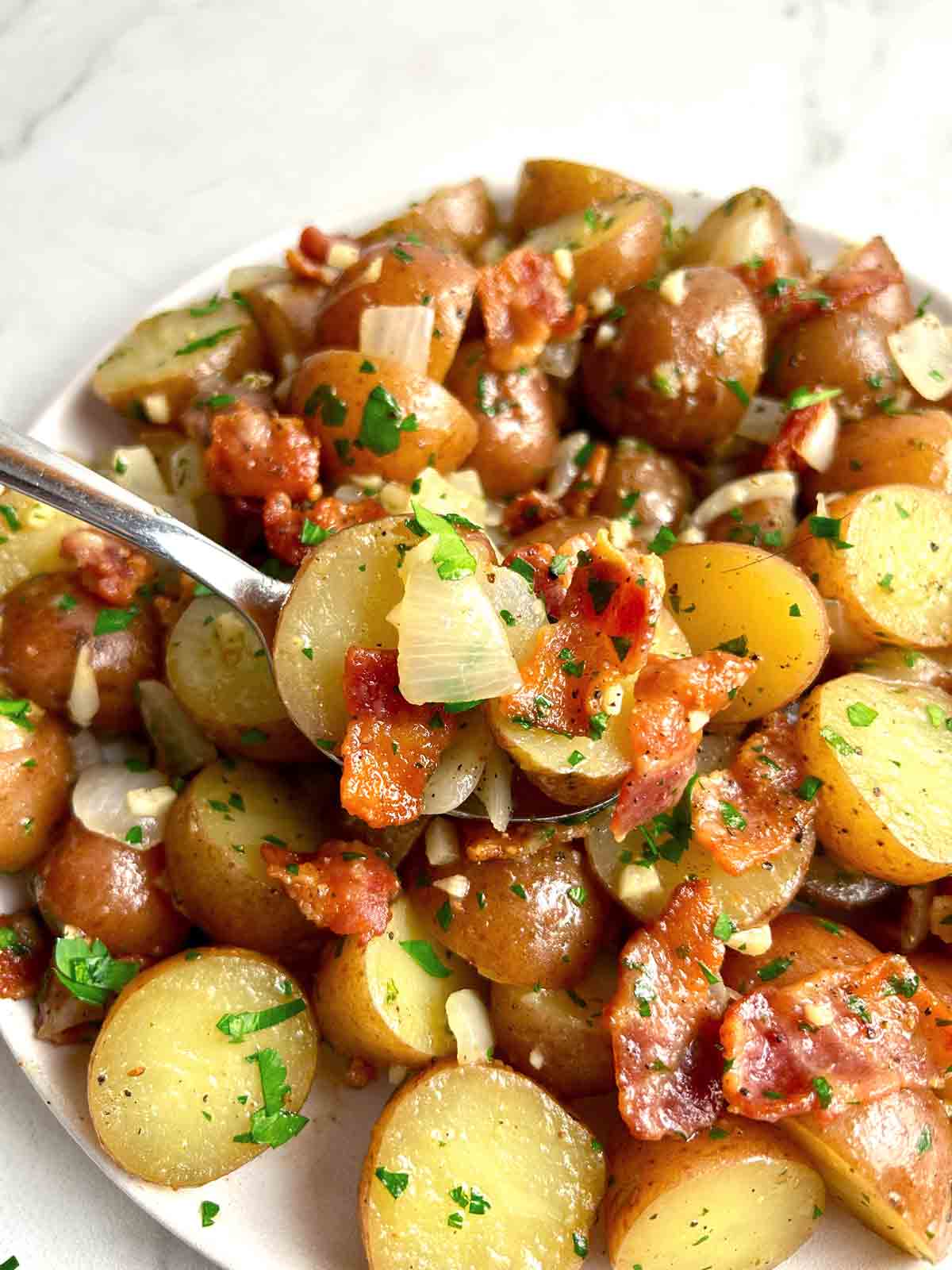 spoon lifting potato salad from plate.
