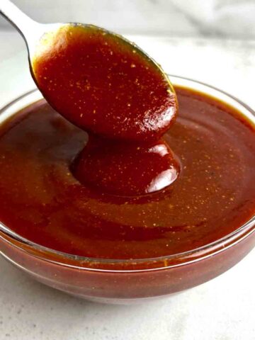 spoon lifting barbecue sauce from bowl.