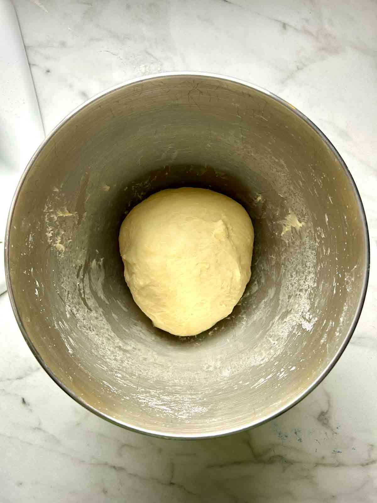 dough kneaded in stand mixer bowl.