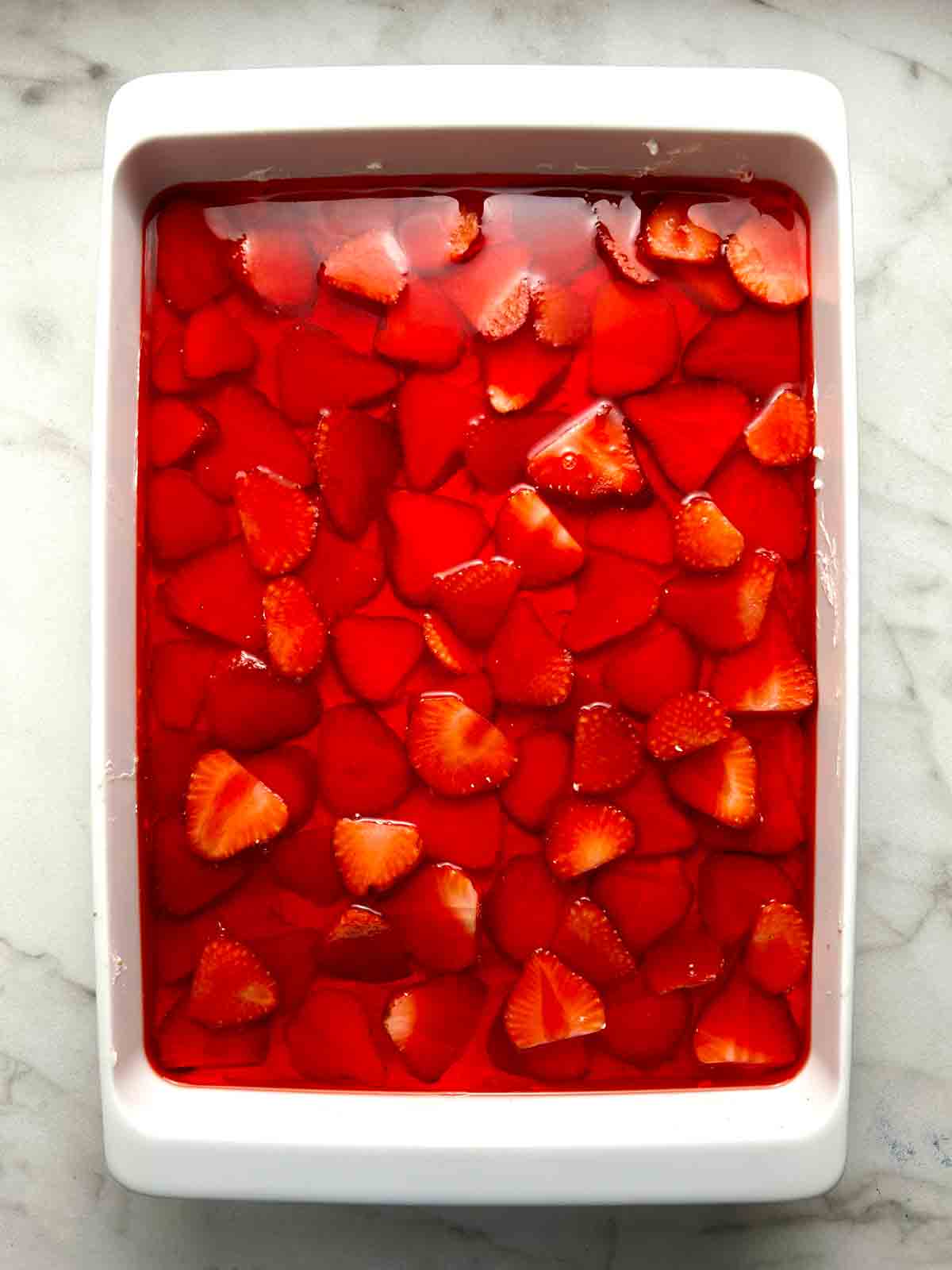 Jell-O mixture poured on top of strawberries.