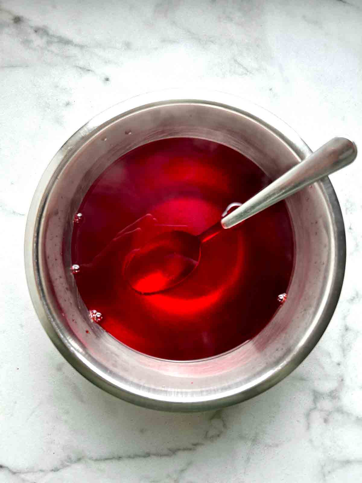 Jell-O powder mixed with boiling water in bowl.