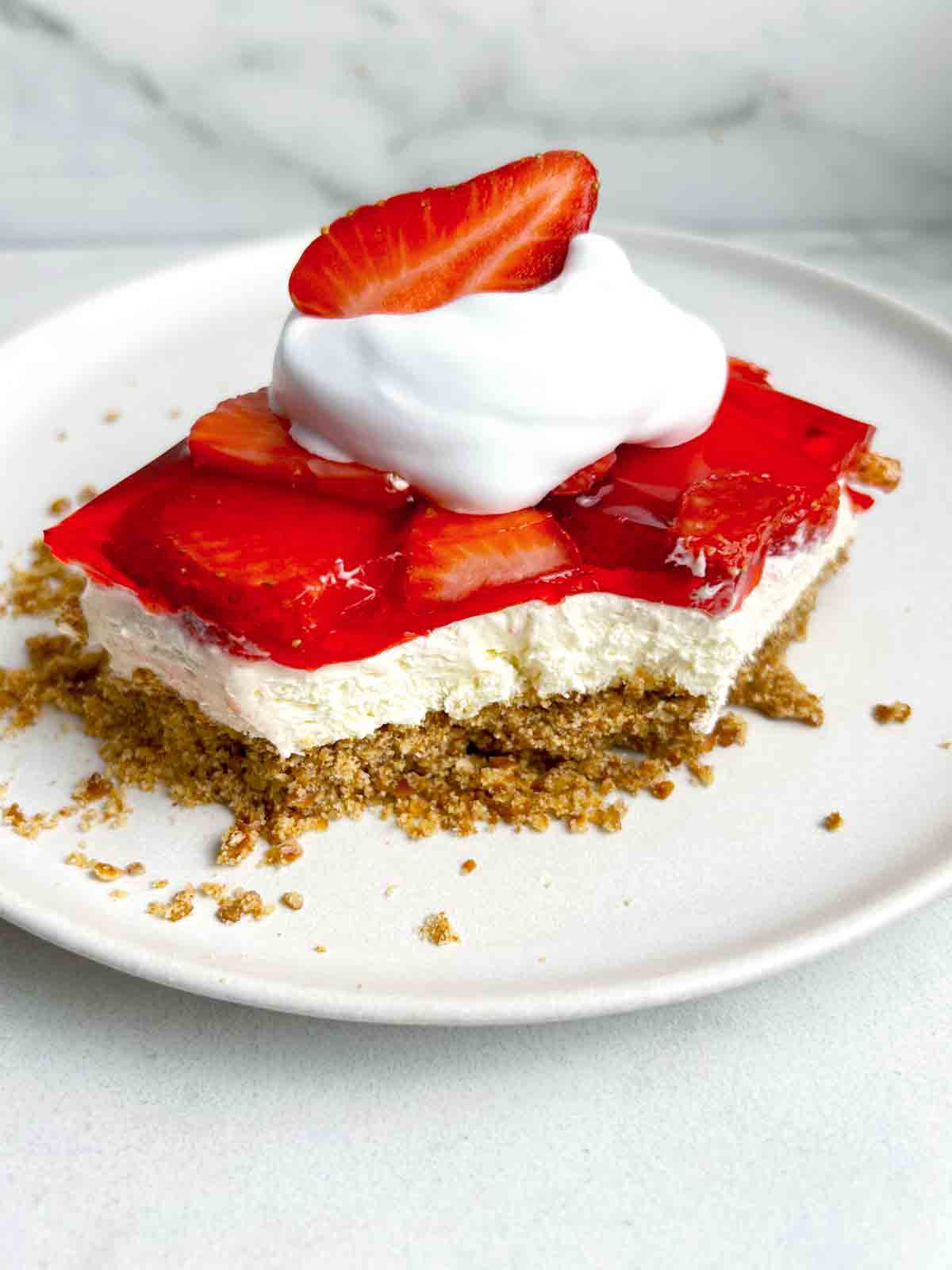 slice of strawberry pretzel salad on plate.