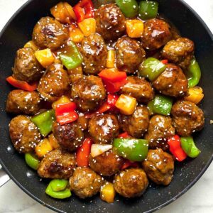 close up of sweet and sour meatballs in skillet.