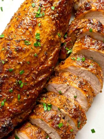 close up of two pork tenderloins; one is sliced.