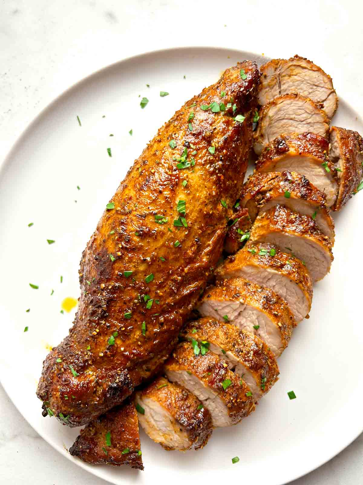 close up of two pork tenderloins; one is sliced.