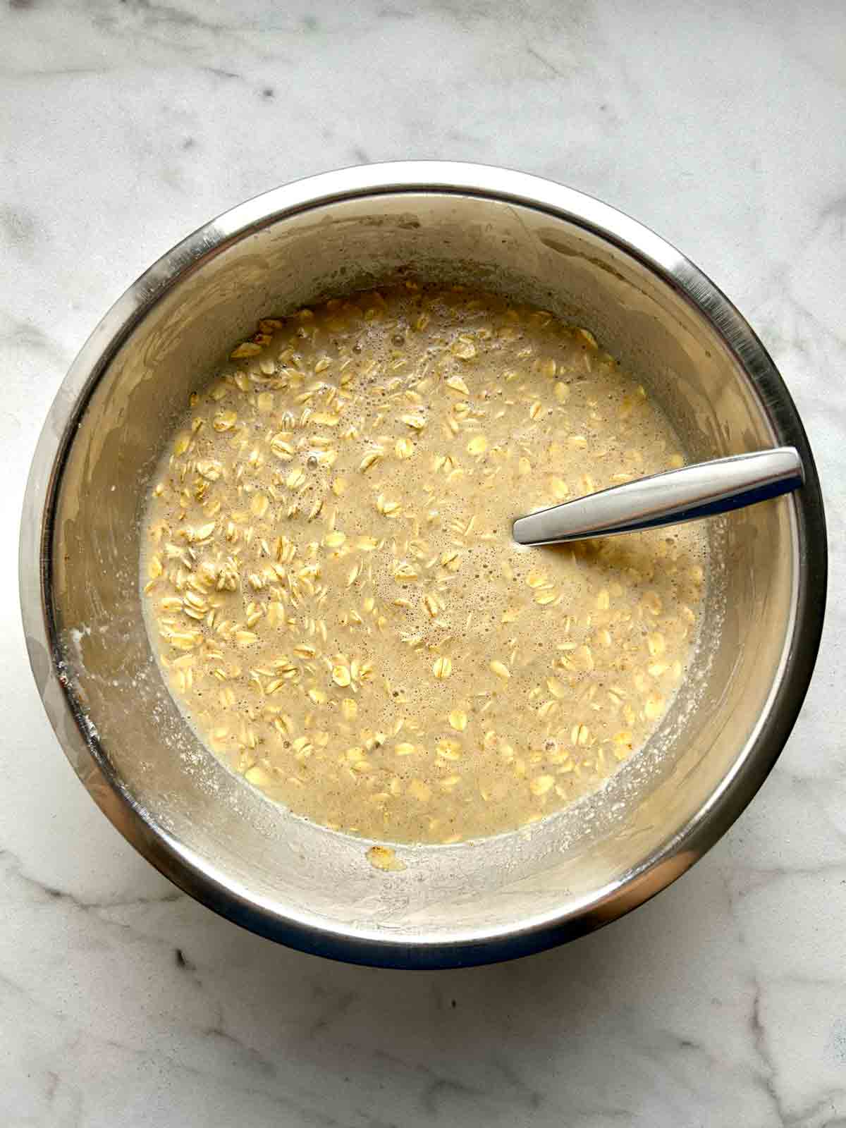 oats mixed with rest of ingredients in metal bowl.