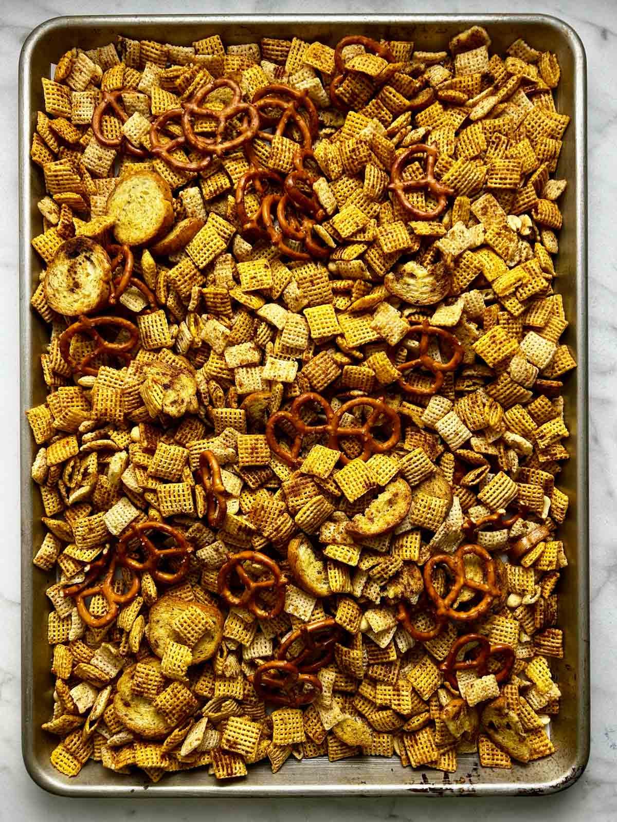 Chex mix after baking; golden brown.