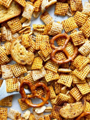 close up spatula lifting of Chex mix from pan.
