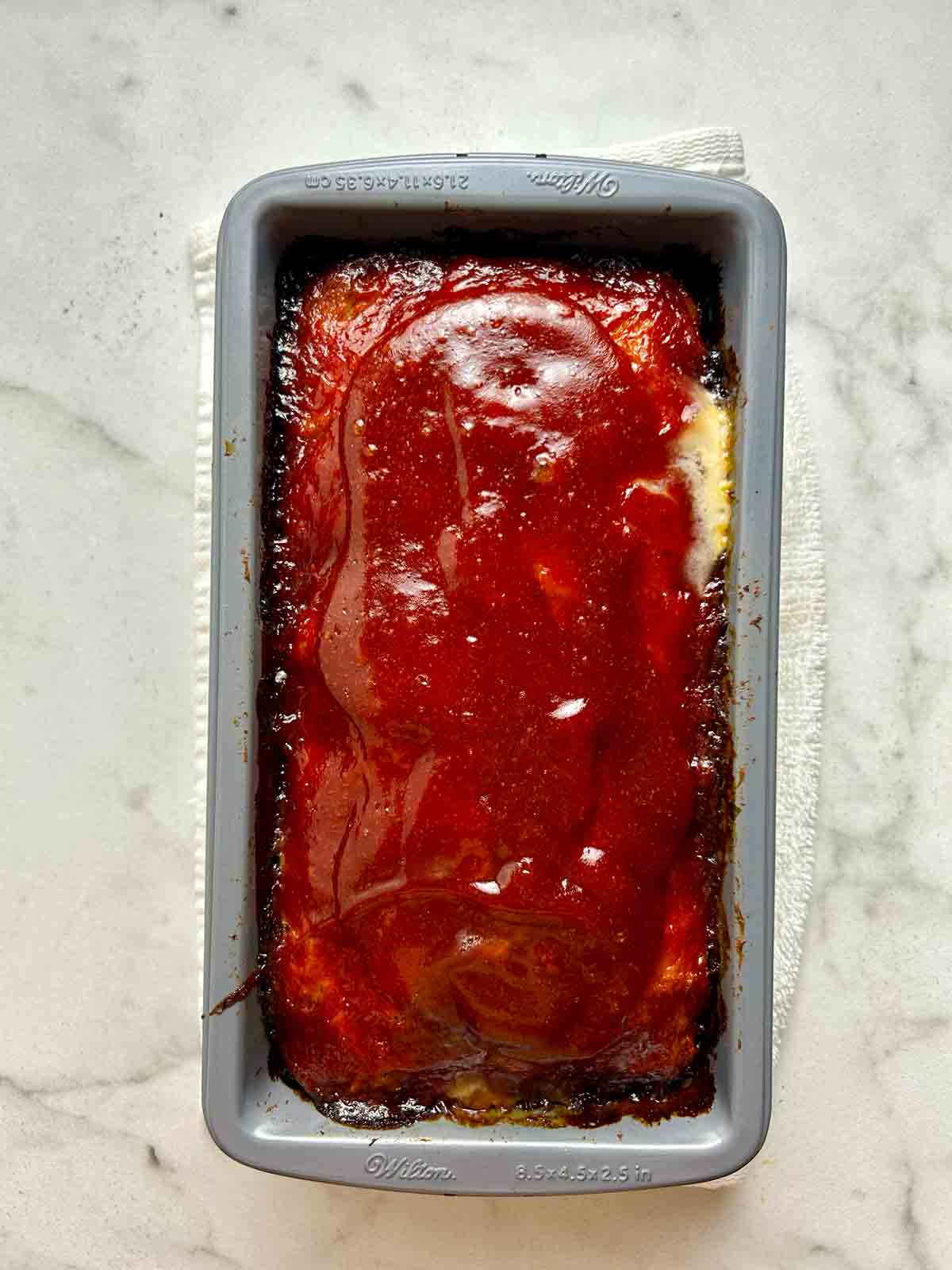 meatloaf after being baked; ketchup is caramelized on the edges.