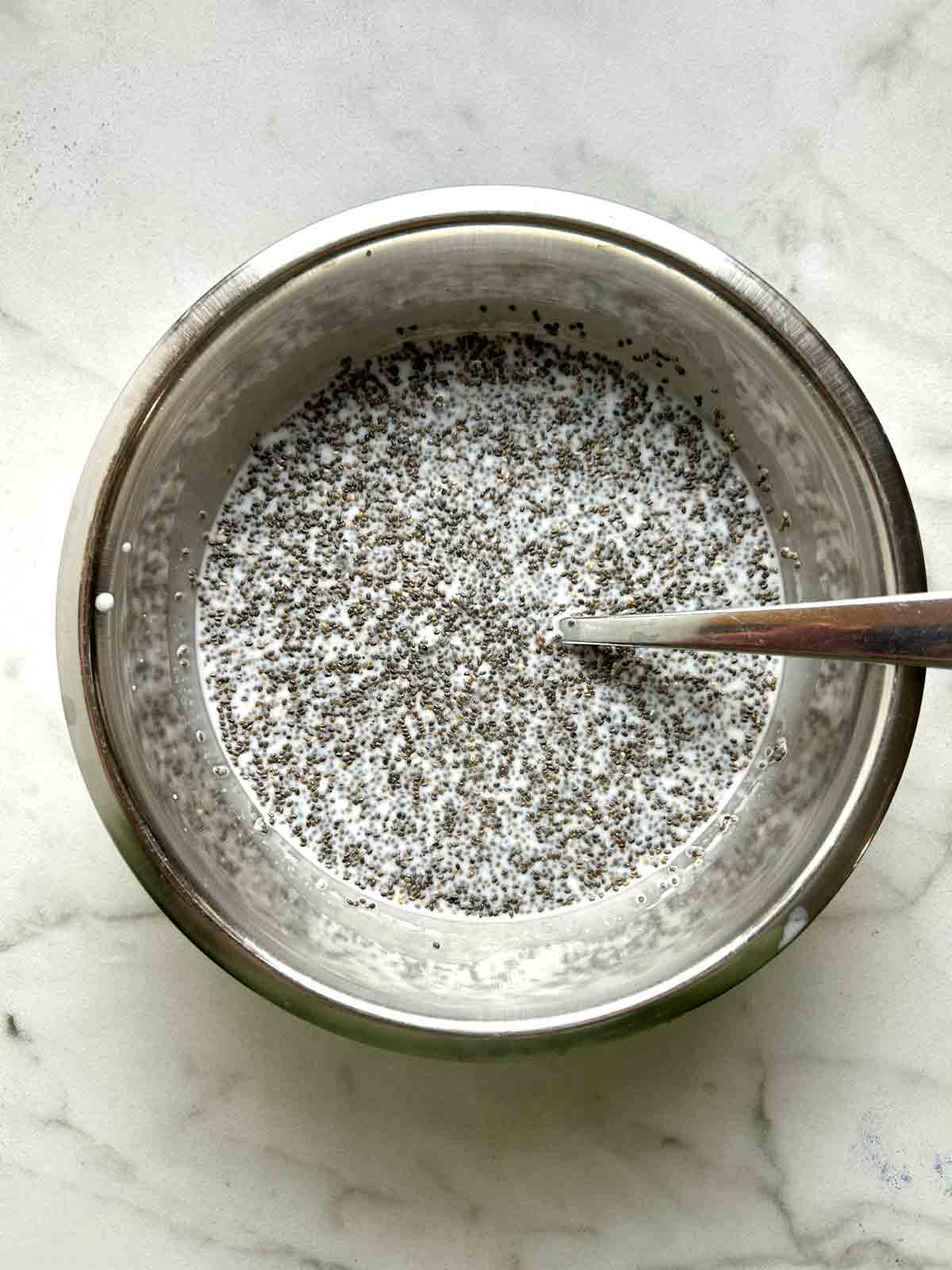 chia seeds mixed with rest of ingredients in metal bowl.